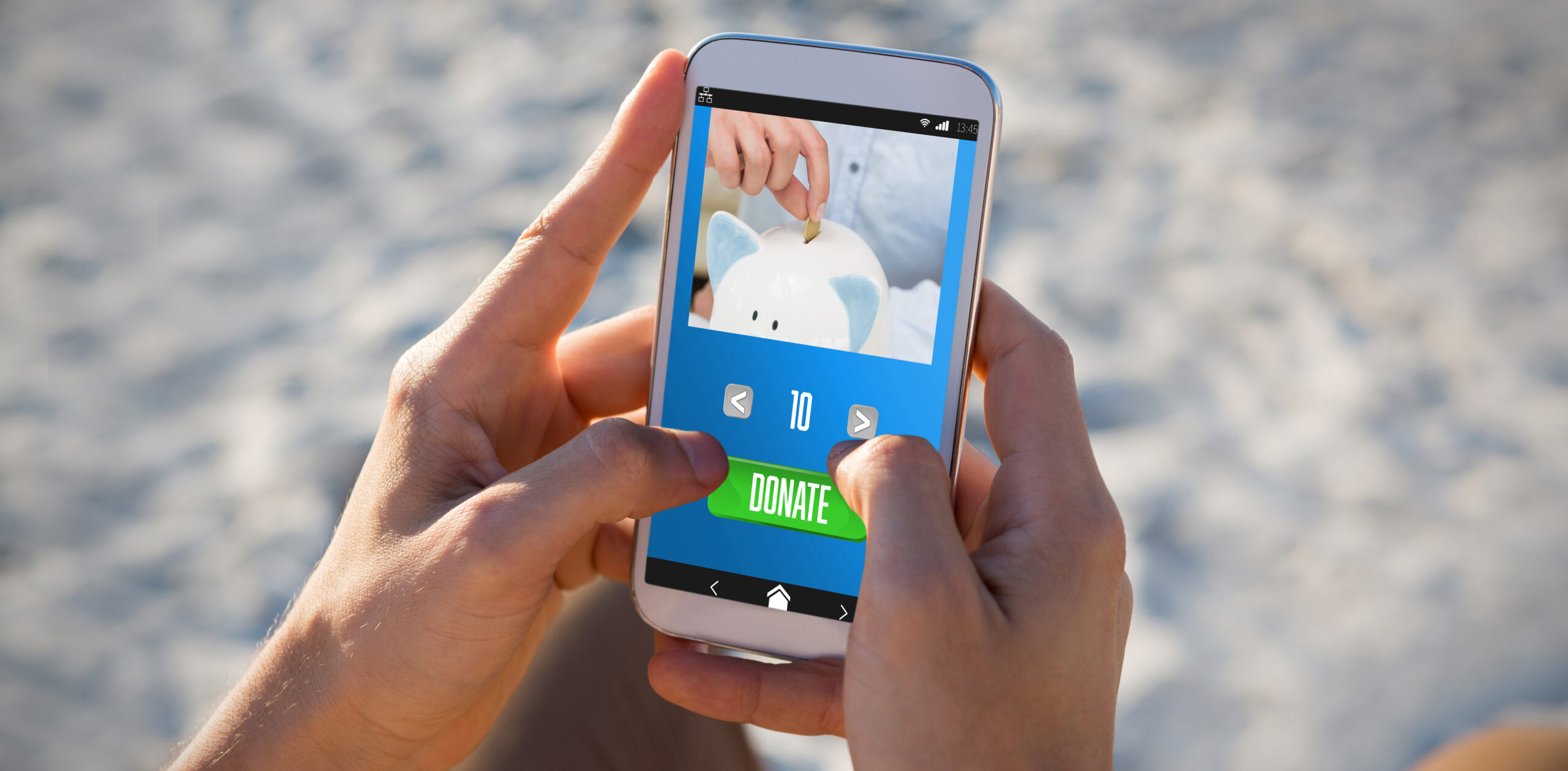 Hands holding a phone, making an online donation using an mobile app