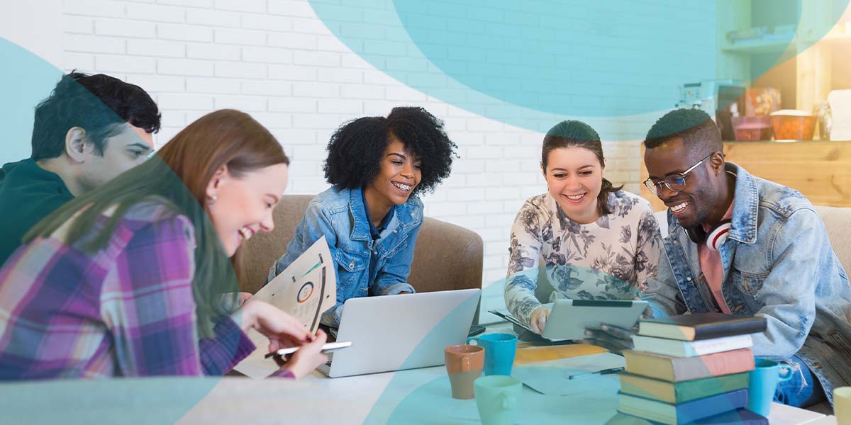 Four people sitting around a computer