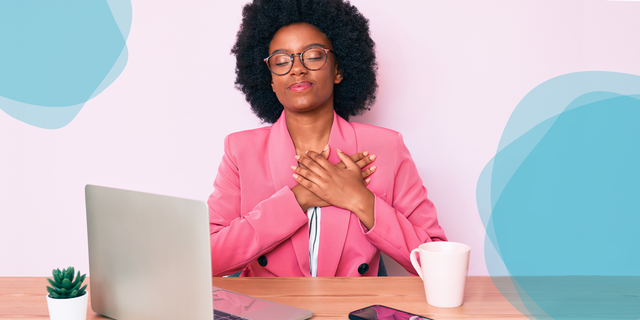 woman sits at her computer with a look of peace on her face as she holds her hands over her heart