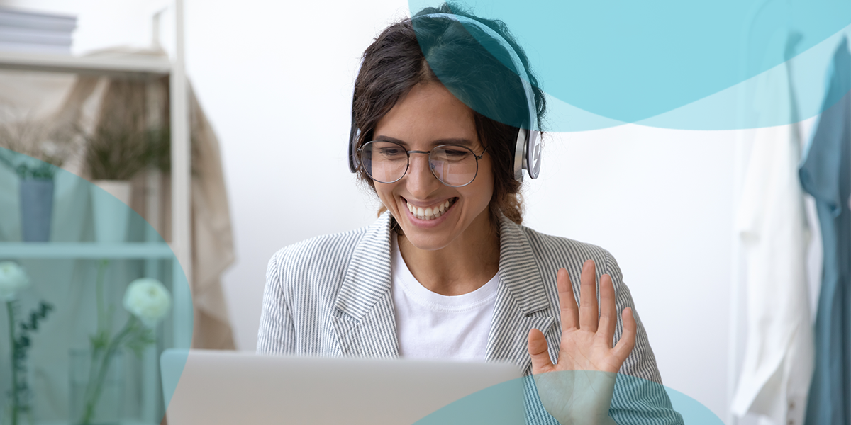 Woman waving to virtual meeting