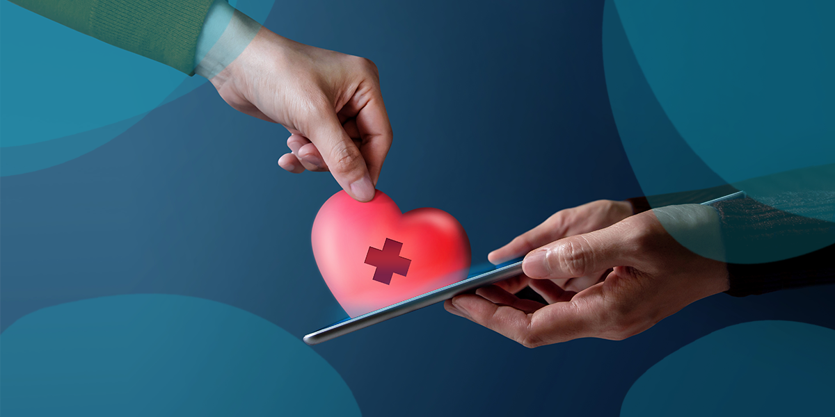 A person putting a symbolic heart into a mobile phone (online donation)