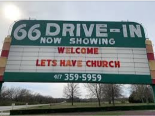 Old looking movie drive in sign says "Welcome, Let's Have Church"